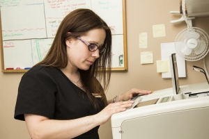 lens edging staff member looking at machine